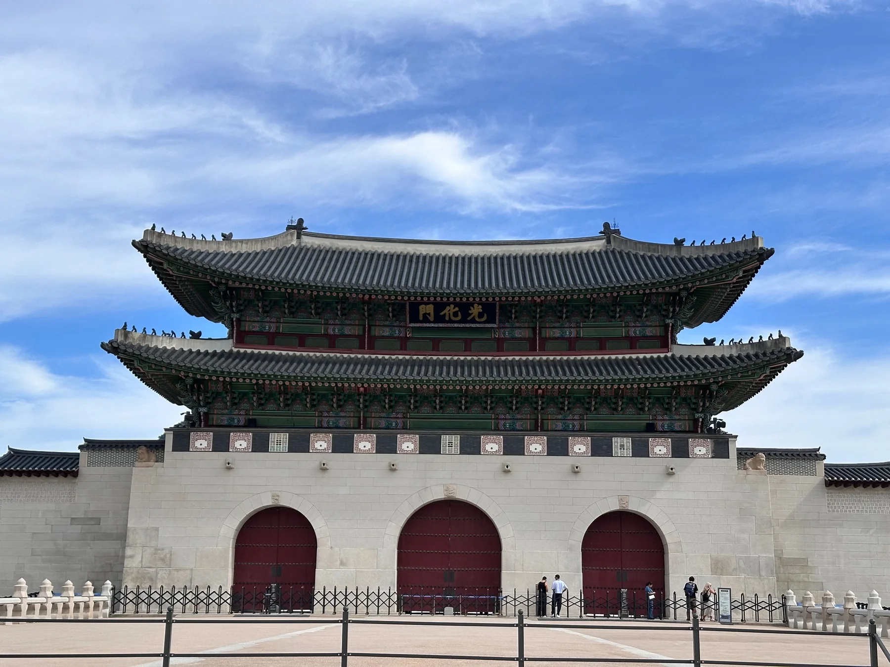 La porte d’un palais traditionnel à Séoul, sous un ciel bleu.